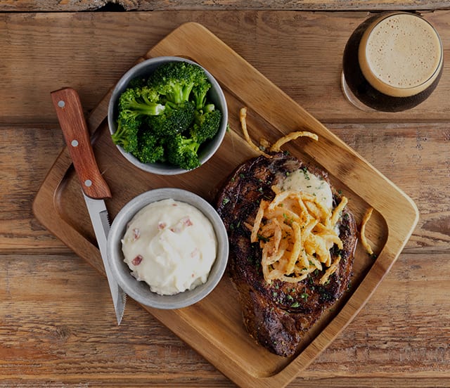 RIbeye steak with vegetables and beer.