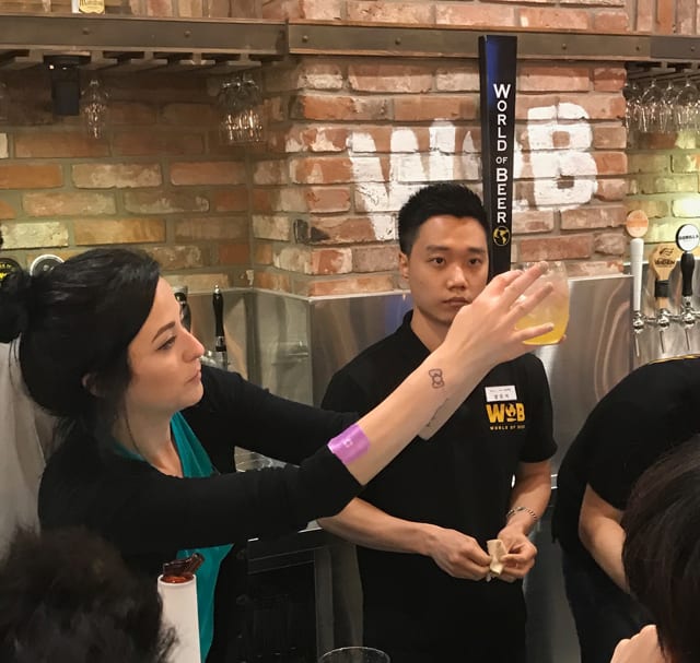 World of Beer manager showing a sangria mixed drink to her employees during training