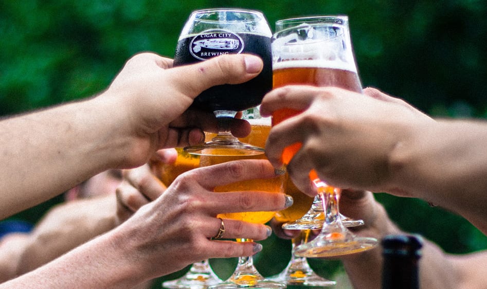 Five people cheering beer together in a circle