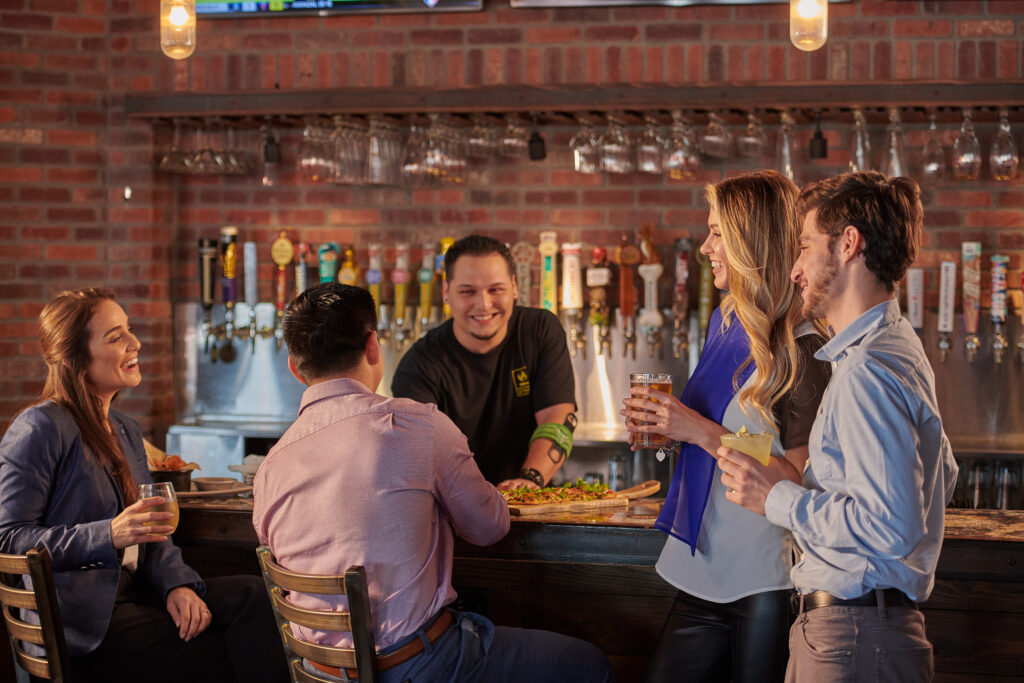 A bartender or server shares a meal with customers.